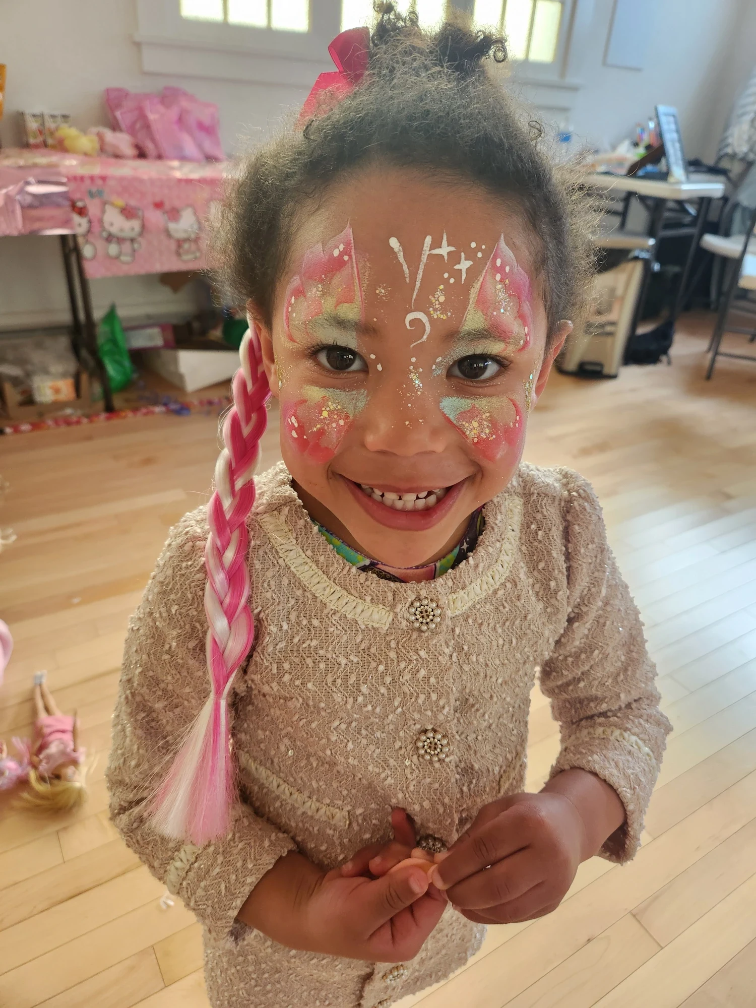 Young girl with a pink and gold glitter butterfly face painting